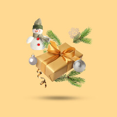 Christmas or New Year celebration. Gift box and festive decor flying on beige background
