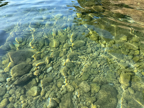 Pebbles and stones in clear sea water.