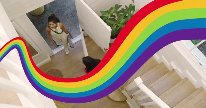 Rainbow graphic sliding across foyer host opening doors hugging friend entering for design tour