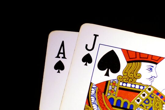 Blackjack bonus concept: Close-up of isolated blackjack cards on a black background, Jack of Spades and Ace of Spades