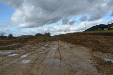 Construction of a railway line in the mountains during autumn – visible earthworks and structural works on engineering objects.