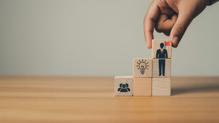 Creative business growth concept with wooden blocks forming upward staircase, teamwork and leadership icons, hand placing final block, symbolizing success, vision, motivation, and strategy.