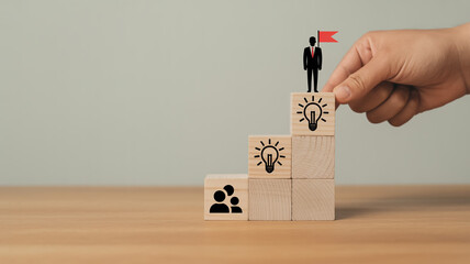 Creative business growth concept with wooden blocks forming upward staircase, teamwork and leadership icons, hand placing final block, symbolizing success, vision, motivation, and strategy.