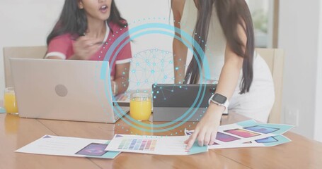 Two graphic designers reviewing designs, tapping and pointing color swatches, choosing final print