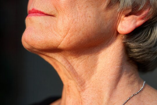 Closeup of a person bathed in evening light, soft expression between nostalgia and acceptance.