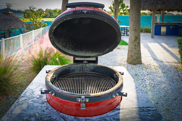 A sleek barbecue grill sits atop a striking red countertop, perfectly positioned for outdoor feasts.