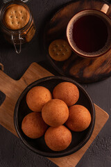 Traditional Colombian buñuelo-fritter with coffee – rustic Latin American breakfast in warm low key lighting