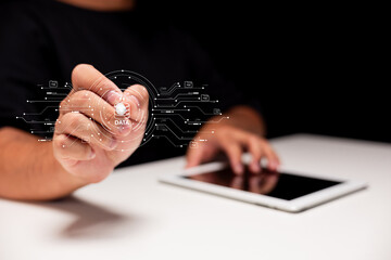 A person interacting with a digital interface, emphasizing data and technology, using a tablet in a modern setting.