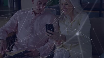 Mature woman tilting smartphone toward man in tech, sharing data while overlay drifting on sofa - Powered by Adobe