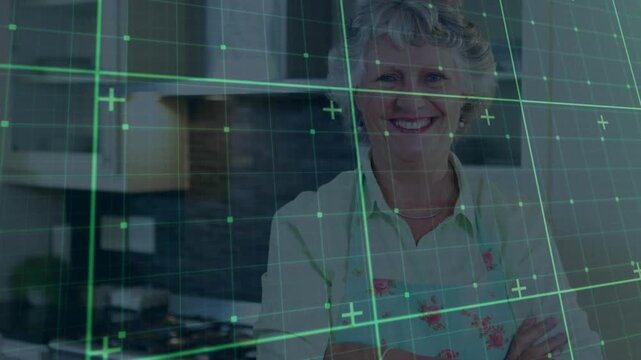 Senior woman standing in kitchen, grid overlay appearing and rotating for technology demonstration