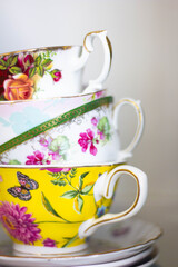 a stack of colorful vintage teacups 