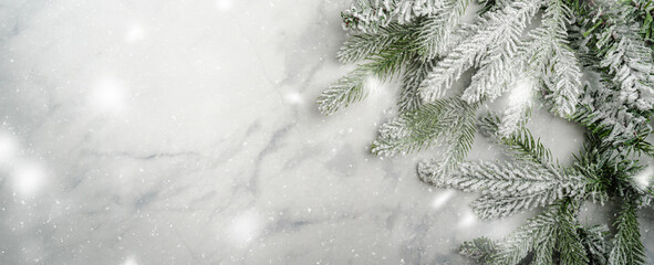 Christmas and New Year background with fir branches with holiday decorations and pine cones on a marble table, banner for holiday screen, template for design. Holiday card