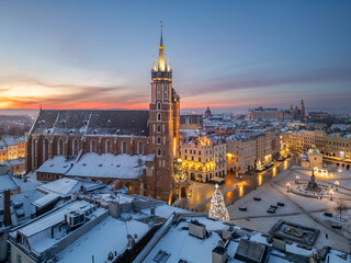 St Mary's church and Christmas tree on the snow covered Main Square in the winter dawn, Krakow,...