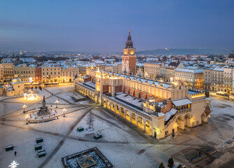 Aerial late night / dawn view of snow covered Main Square with Cloth Hall and Town Hall Tower in Krakow, Poland