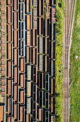 Many railroad cars (rail cars) of different cargo types on multiple parallel railway tracks, seen from above the railway station