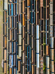 Many railroad cars (rail cars) of different cargo types on multiple parallel railway tracks, seen from above the railway station