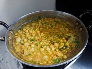 Indian-style matar curry cooked with tomatoes, onions, and spices, simmered to perfection and garnished with fresh coriander in a traditional pan.