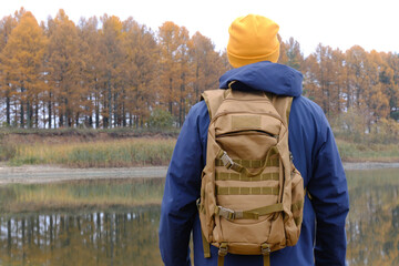 Man backpacking exploring autumn nature by lake