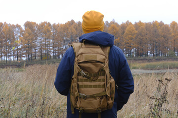 Man hiking with backpack enjoying autumn nature outdoors