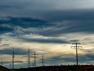 Hochspannungsmasten unter einem bizarren Wolkenhimmel
