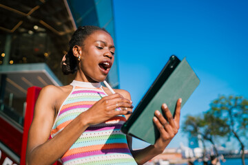 Excited woman reacting to news on tablet, mouth open in surprise, showing genuine emotion and connection through mobile technology in modern digital lifestyle. © BullRun