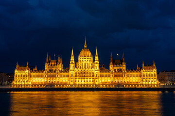 Fototapeta premium Budapest Parliament Building Illuminated at Night With the Danube River in Hungary