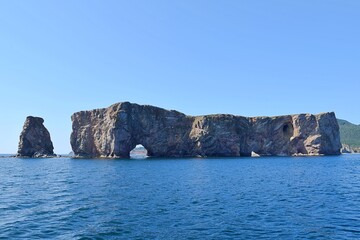 Obraz premium Le Rocher Perce, famous rock in Gaspesie, Quebec, Canada with a beautiful blue sky