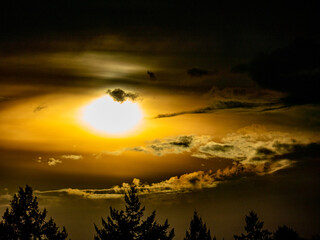Sonne trinkt durch dunkle Wolken