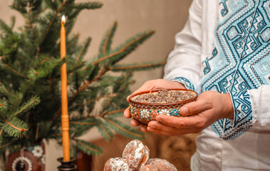 Traditional Ukrainian kutia served on Christmas Eve in ceramic bowl with embroidered shirt, festive ritual dish with wheat and poppy seeds, kutia for Holy Supper in authentic ethnic setting