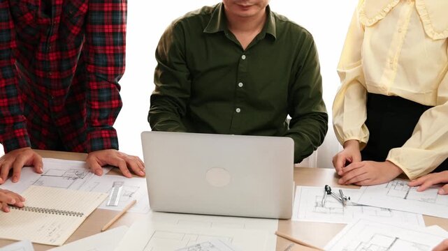 Smart architect and safety engineer discussion about building plan on table with architectural document, measurement tools and wooden block scatter around at modern office. Closeup. Delineation.