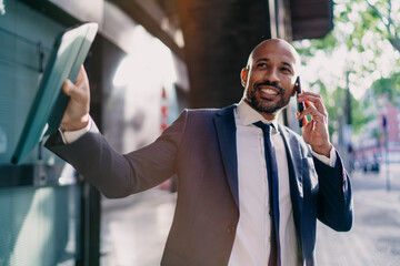 Businessman smiling and gesturing during call with tablet in hand, showing positivity, success and...