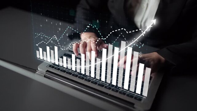 A professional using a laptop to analyze financial data with digital graphs and charts illustrating growth. This modern workspace highlights technology and analytical skills. Copula