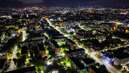 Night panorama of Ostrów Wielkopolski drone view illuminated streets residential blocks urban housing city lights wide cityscape at night skyline