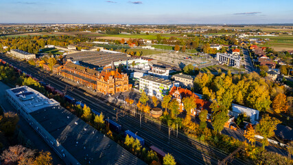 Skalmierzyce. Drone view of the historic railway station building, surrounding town development and railway tracks in an autumn small-town landscape
