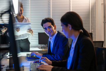 Corporate professionals businesswoman and businessman collaborating on innovative technology project with computers and documents in modern office