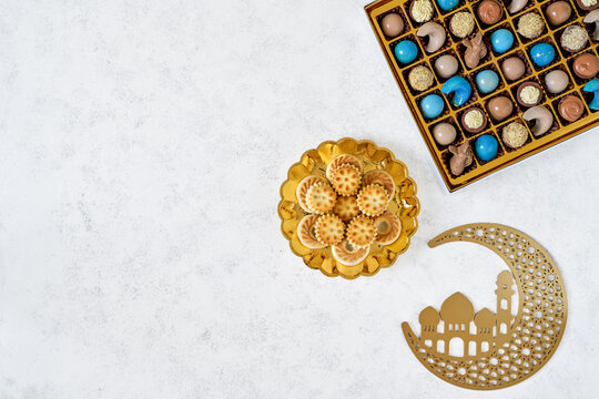    Traditional arabic Eid al Adha, Eid al Fitr , Ramadan sweets with golden moon decor. Colorful chocolate candy, semolina maamoul cookies with arabic coffee. Top view