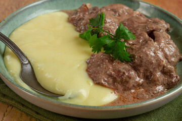 liver beef stroganoff with mashed potatoes, table setting in green tones, homemade,
