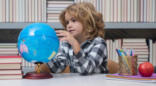 Cute pupil looking at globe in library at the elementary school. School child. Kid boy from elementary school. Pupil go study. Clever schoolboy learning. Kids study, knowledge and education. - Powered by Adobe