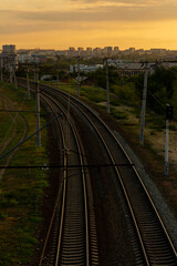 Fototapeta premium Sunset view of railway tracks winding through city landscape