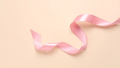 Single pink ribbon spiraled on beige background—evoking softness, elegance, and symbolic simplicity.