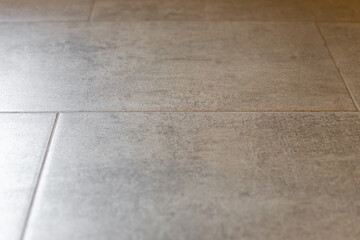 A close-up of a gray tile floor in a modern interior