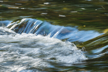 photo of a river with a small waterfall