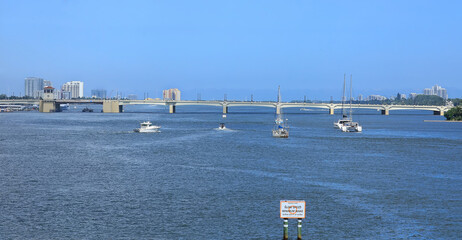 Boating in South Florida, busy day on the water as many boats travel north on Lake Worth Lagoon towards the Flagler Memorial Bridge in Palm Beach, Florida, USA.