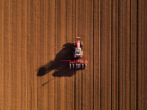 Tractor seeding agricultural field during spring planting season