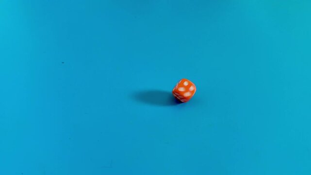 Orange die with spots on blue background