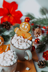 Gingerbread man cookie in cup of hot cocoa with marshmallows and festive decor