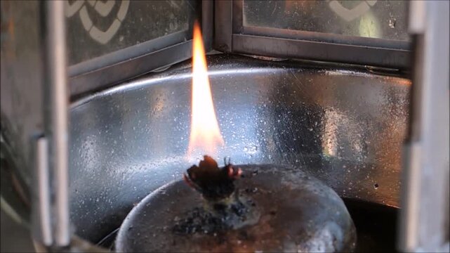 A fire burns in an oil lamp by the wick soaks up liquid oil through capillary action, which then vaporizes at the top of the wick and burns as a gas, it's form of lighting