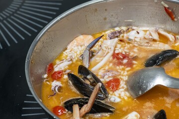 Close-up of delicious fish pasta cooked with fresh tomatoes and garlic sauce on a dish