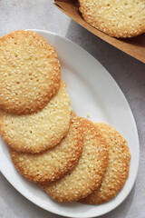 Sesame cookies in a plate on a gray table