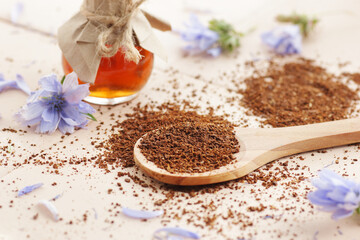 Ground chicory root powder in a wooden spoon, healthy coffee substitude drink, closeup, natural...